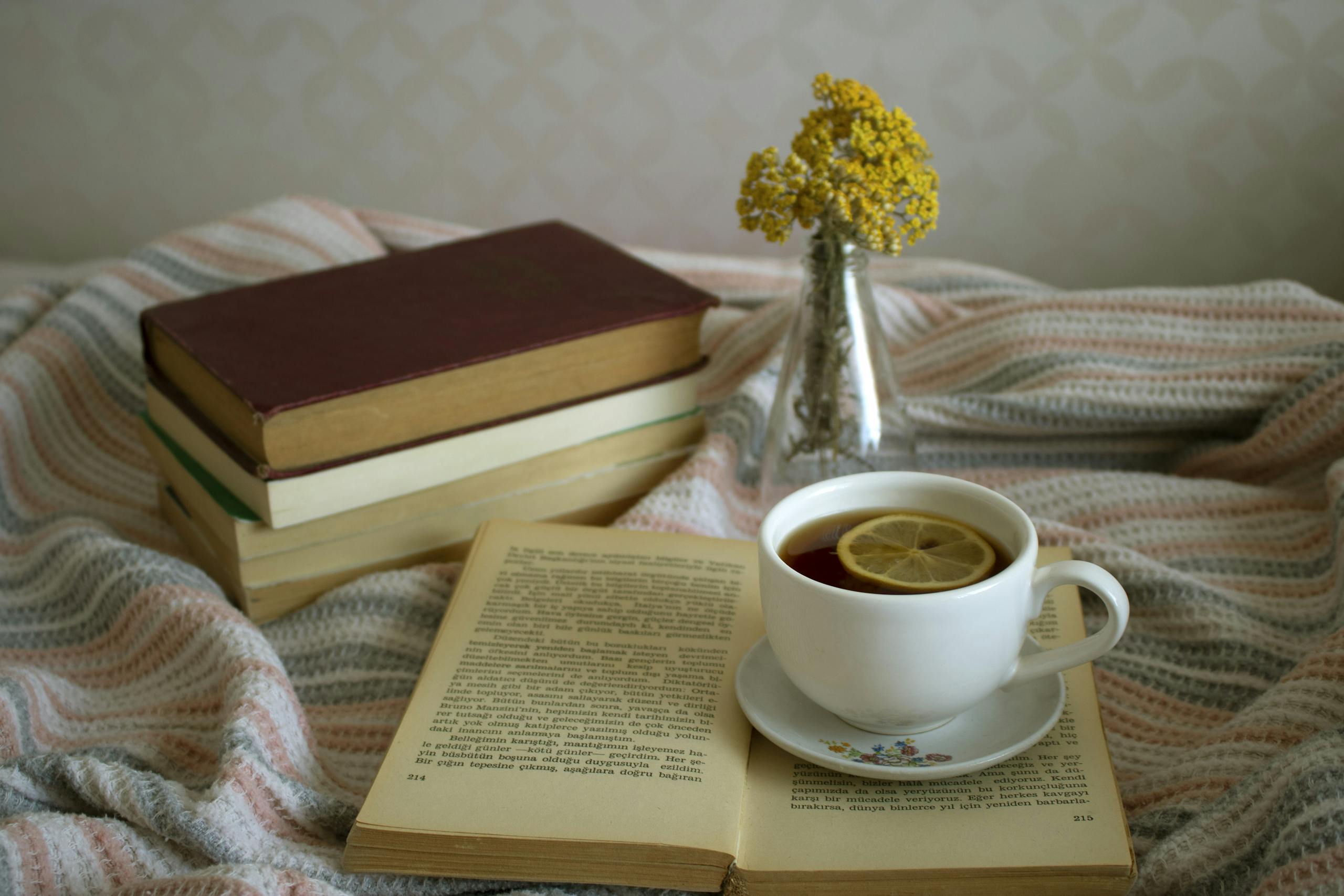 Tea with lemon and stacked books on table evoking evening relaxation ritual