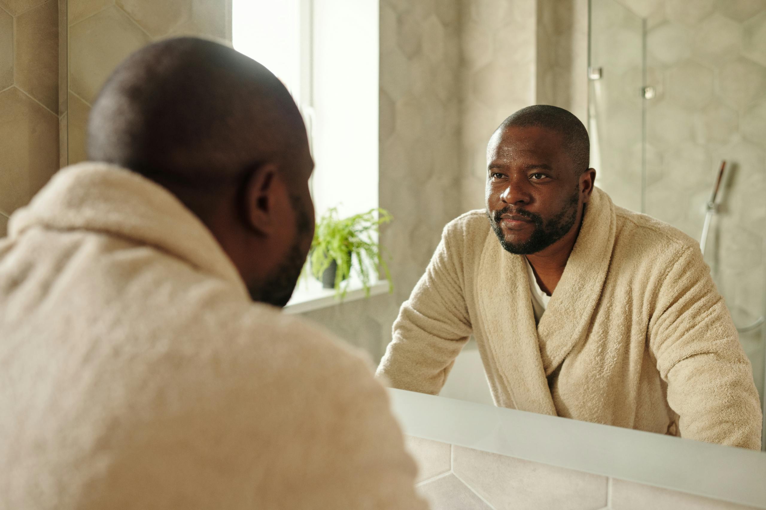 Man preparing for the day in bathroom mirror reflecting wellness morning routine