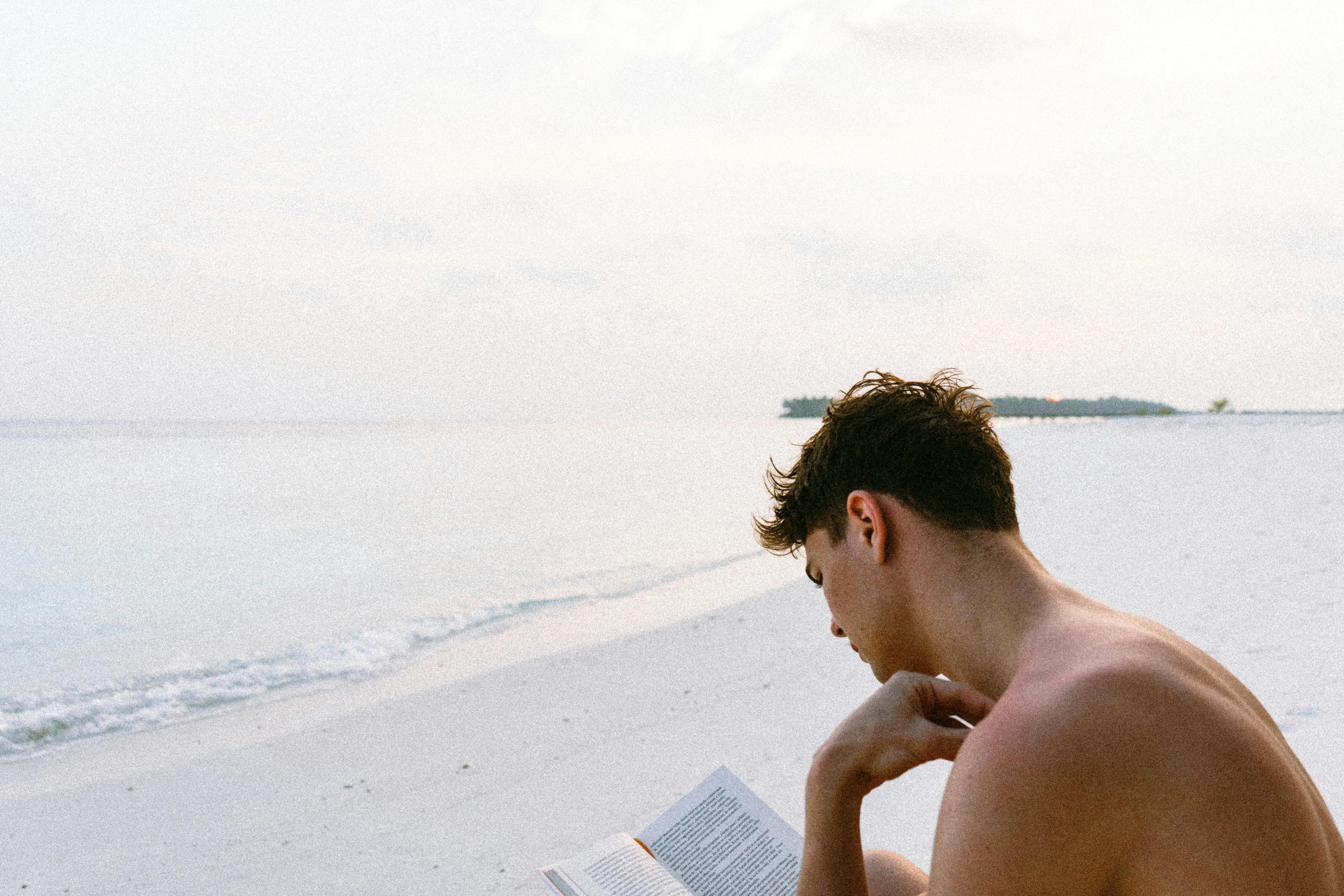Person relaxing with book in cozy living room during evening wind-down routine