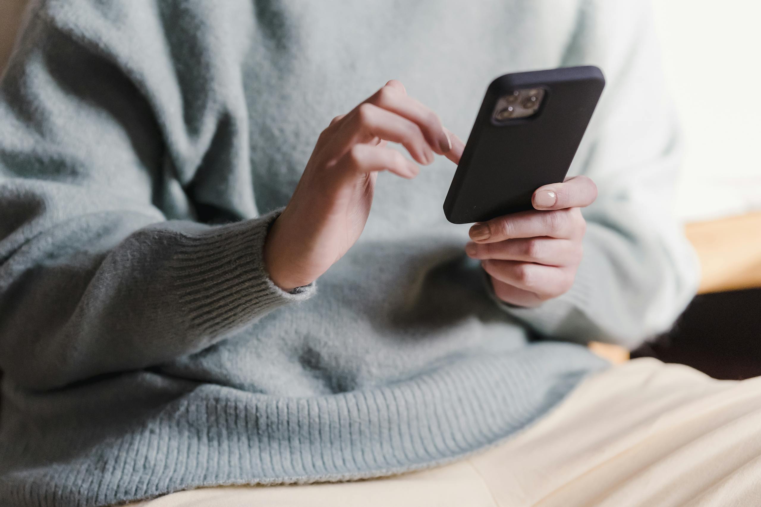 Smartphone displaying sleep tracking wellness app with HRV metrics in comfortable reading space