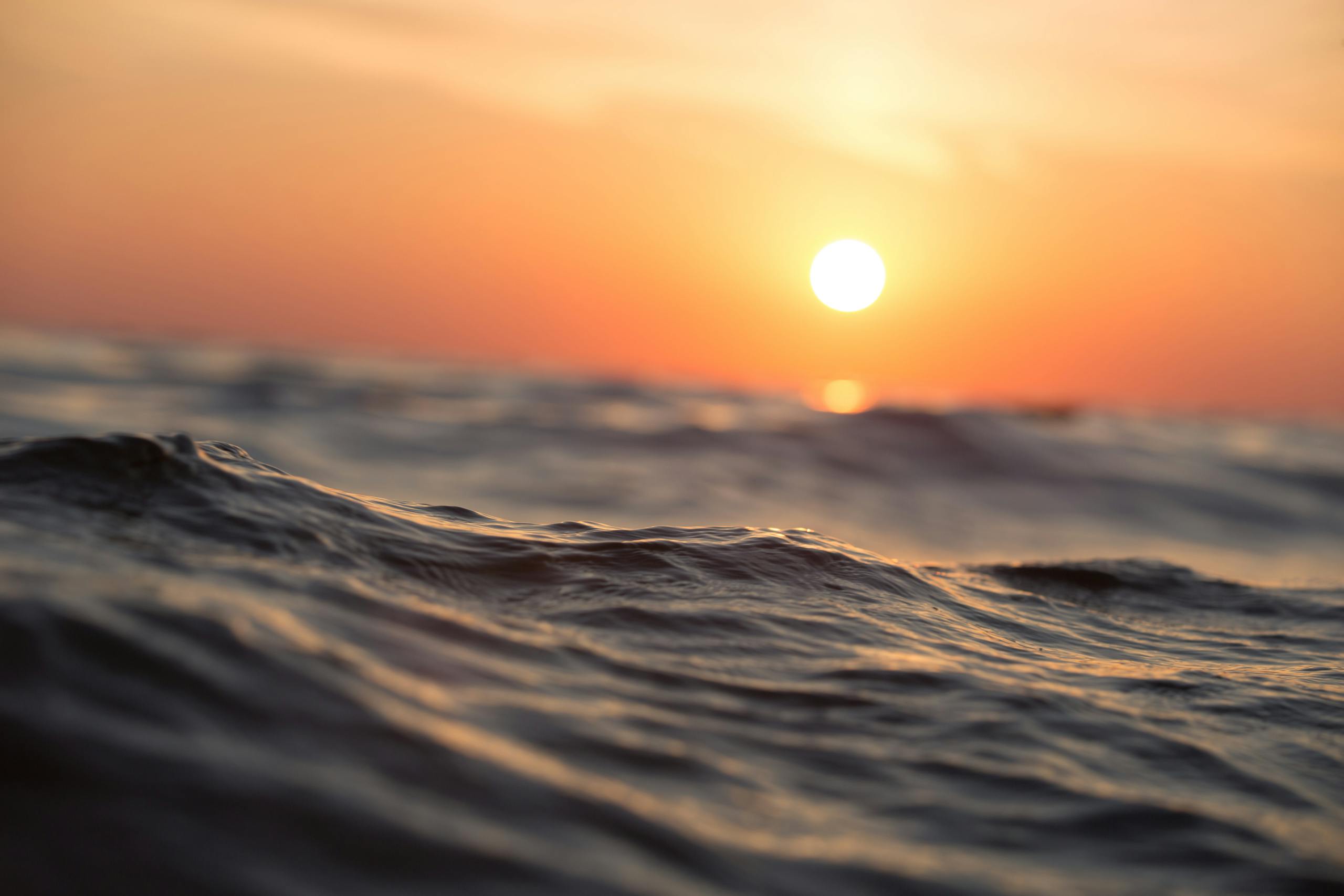 Serene sunrise over calm water representing restful mornings after quality sleep