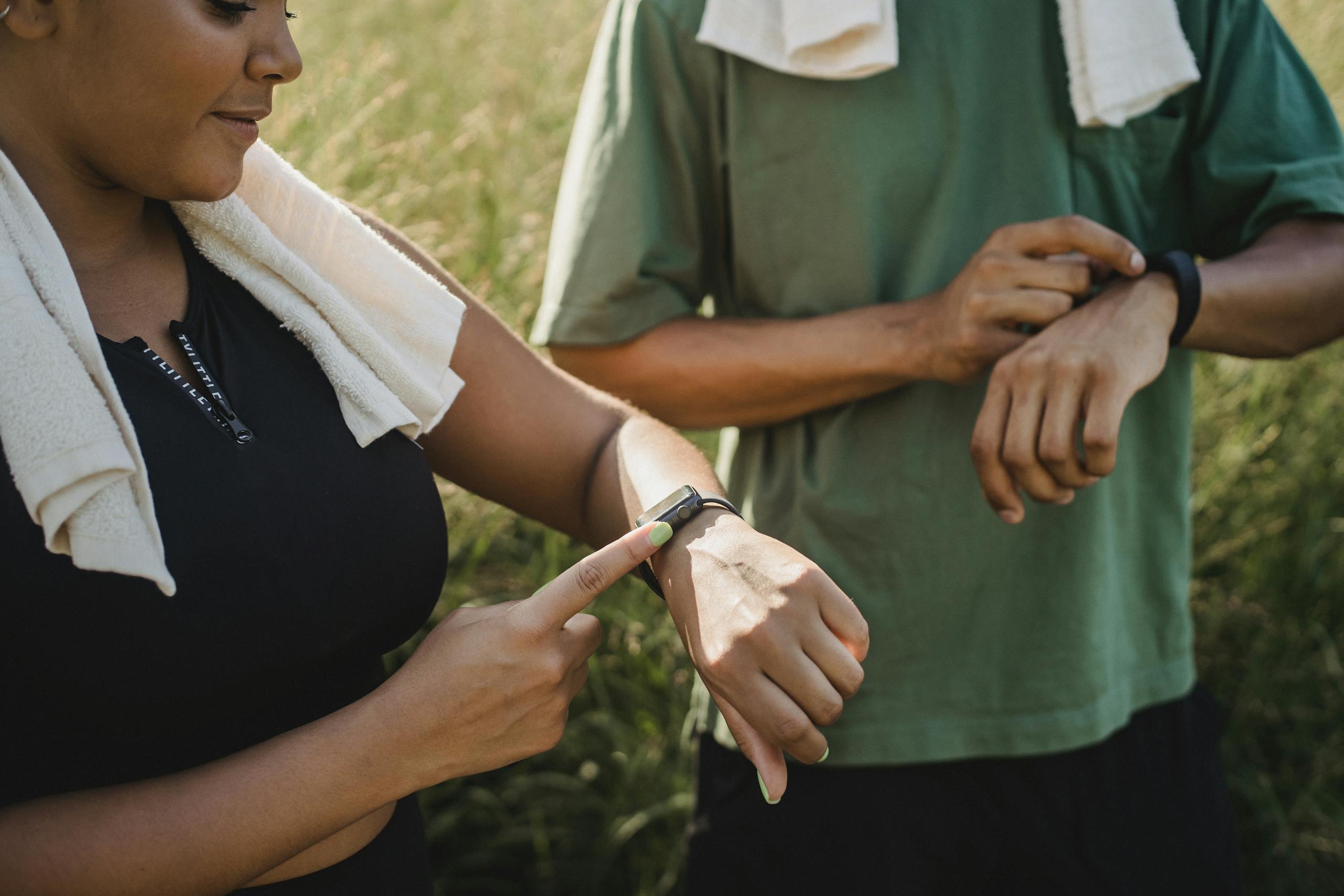 Athletes checking fitness watches to track recovery metrics during training break